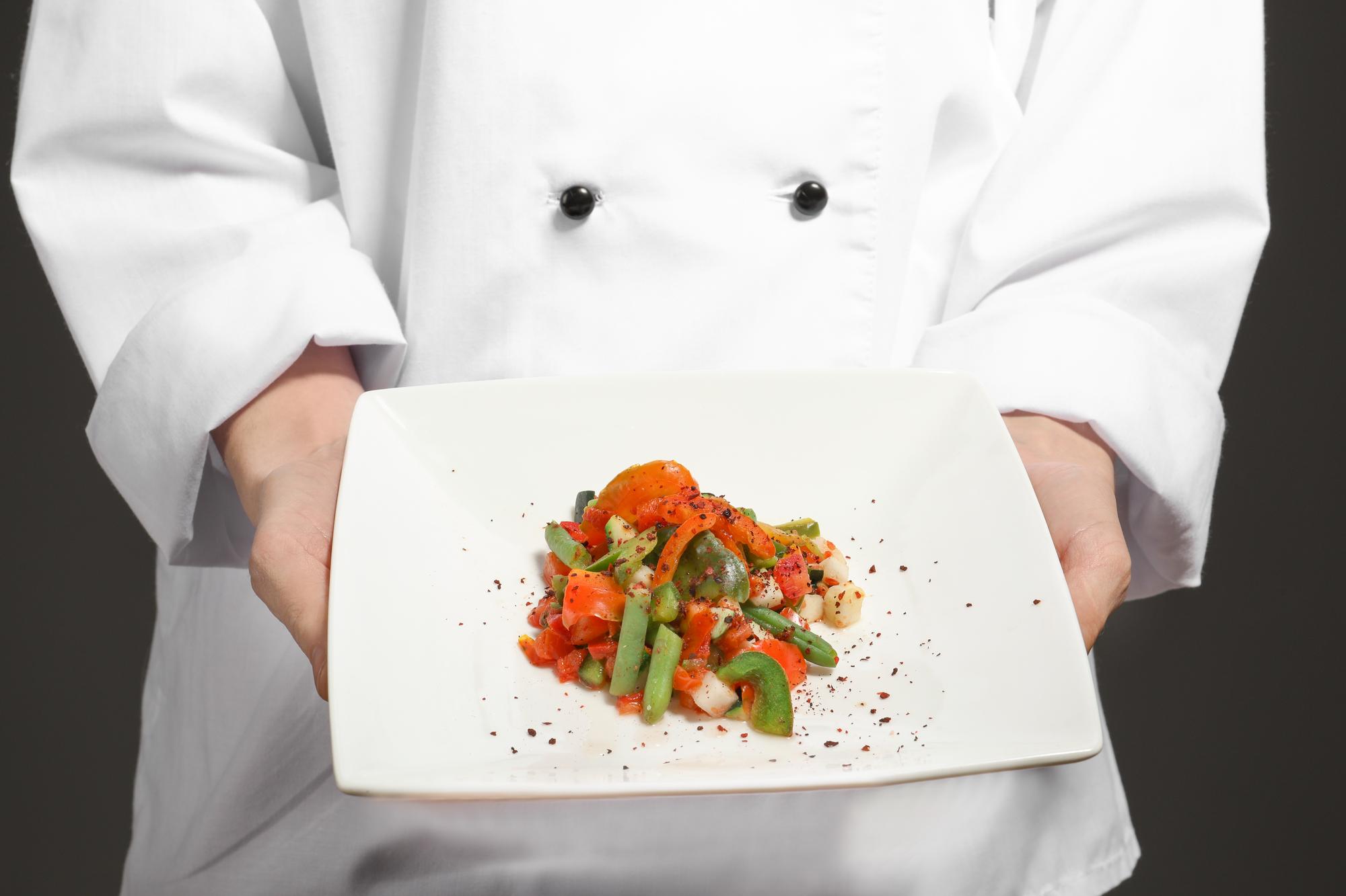 Chef che sistema un piatto in studio cucina